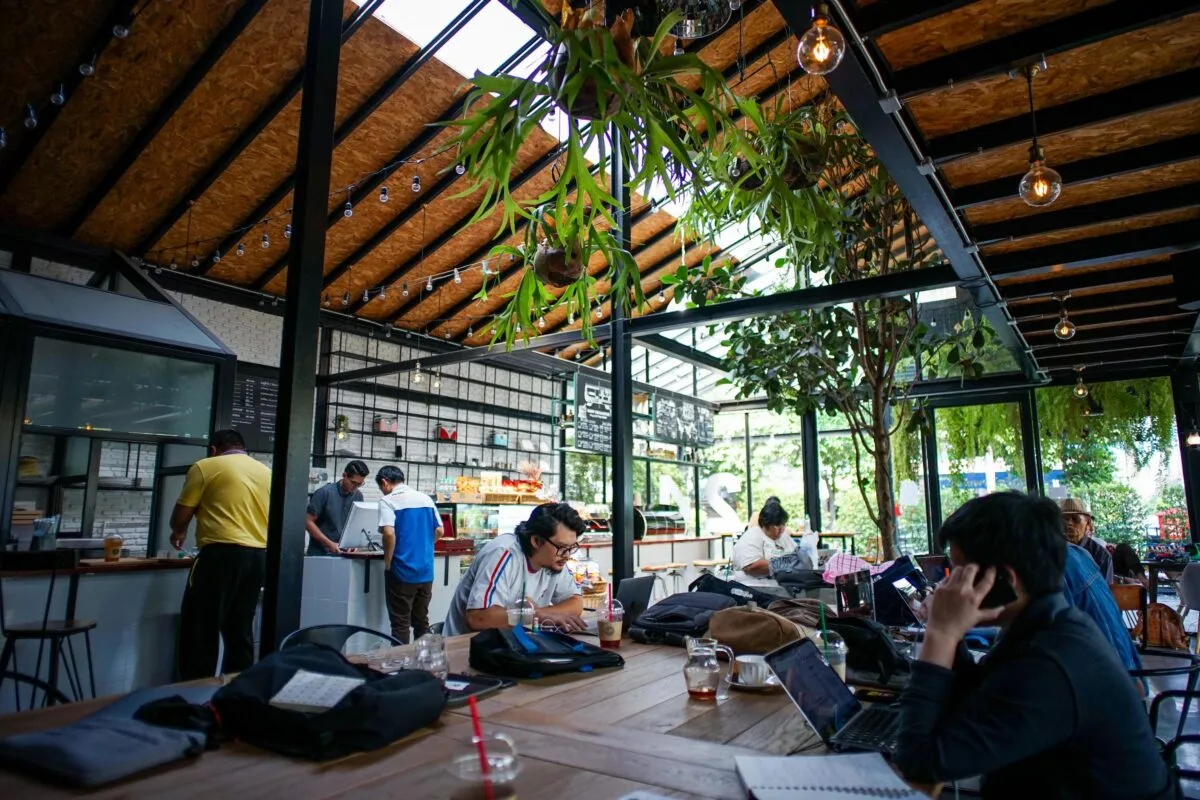 People sitting in a cafe at Thailand reading and working ordering coffee